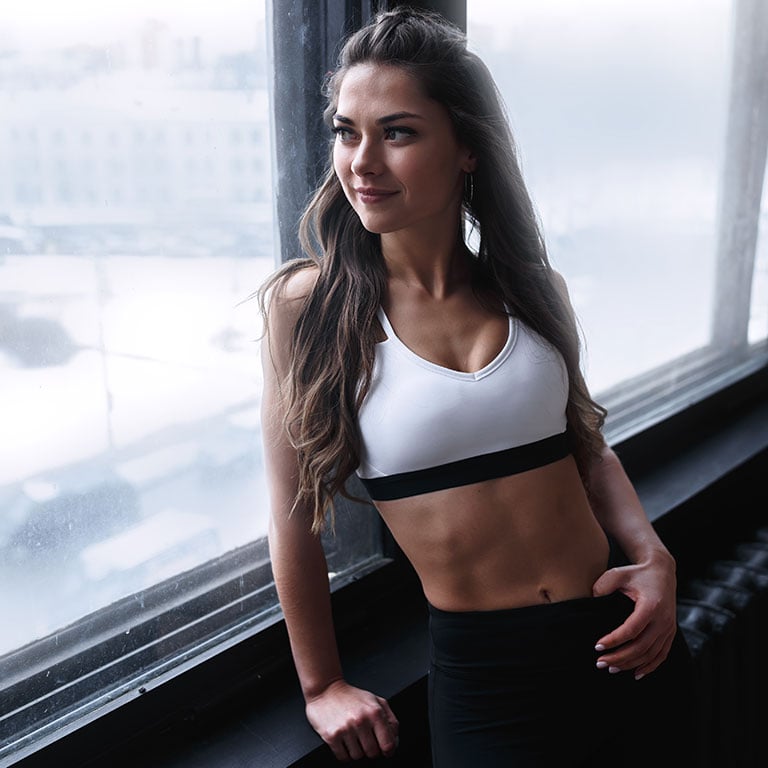Fit woman with defined abs you can get yourself with CoolTone